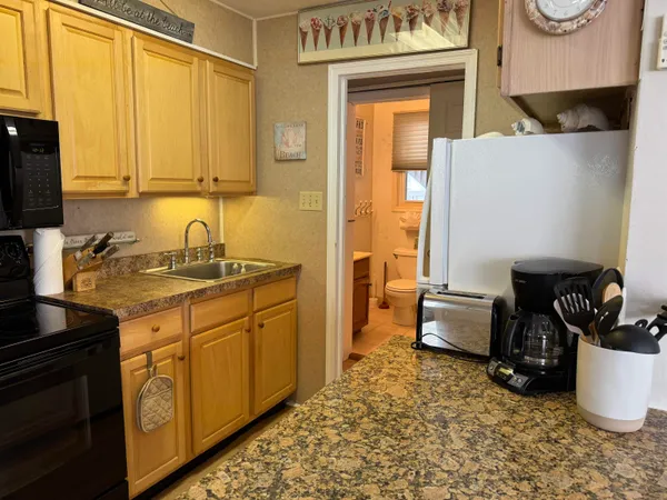 a kitchen with sink a refrigerator and cabinets