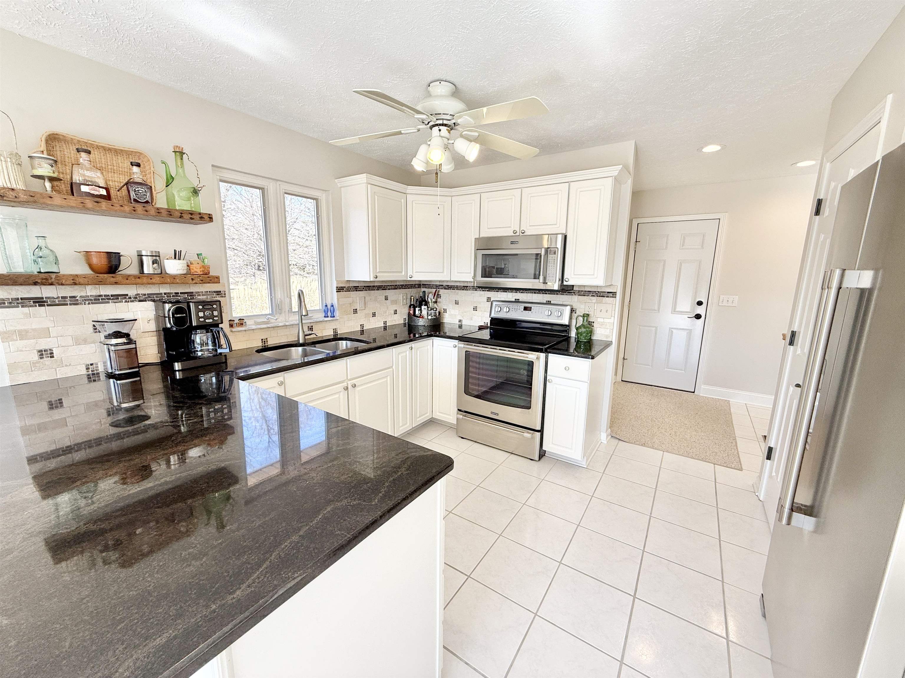 7188 Edwardsville Road Rockford, IL 61102 - Photo 19 of 73 a kitchen with stainless steel appliances granite countertop a sink stove and refrigerator
