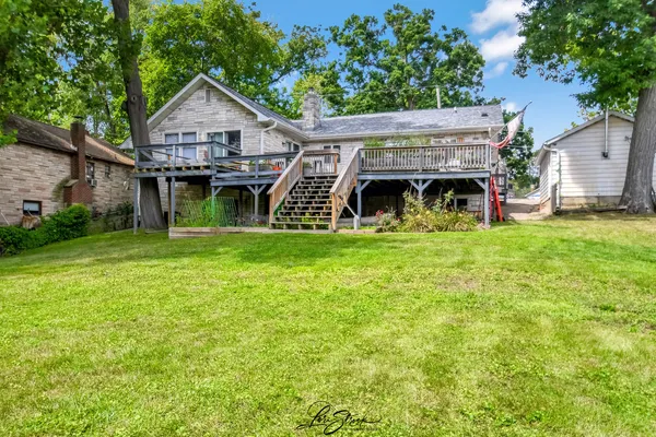 a view of a house with a big yard and large trees