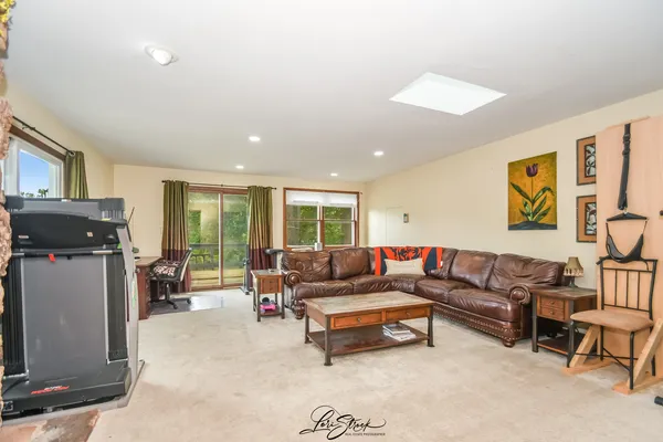 a large kitchen with stainless steel appliances granite countertop a refrigerator a stove top oven a sink and dishwasher with wooden floor