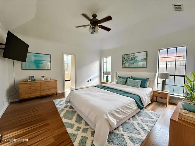 a bedroom with a bed a couch and a flat screen tv