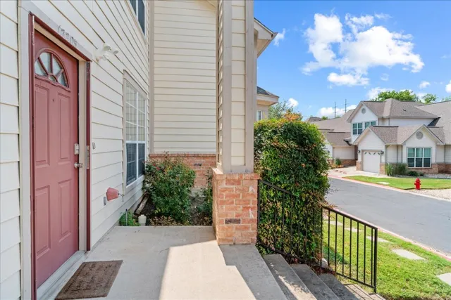 a view of a house with a yard and potted plants
