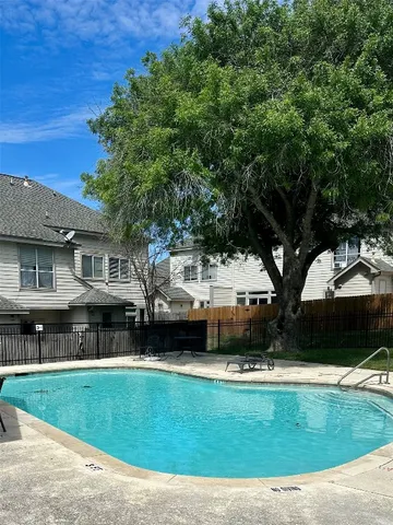 a front view of a house with a garden and a tree