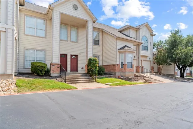 a view of a house with basketball court and a large tree