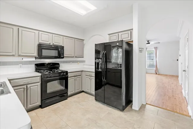 a kitchen with stainless steel appliances granite countertop a refrigerator stove and microwave