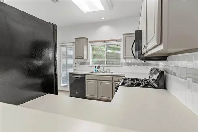 a kitchen with stainless steel appliances a sink stove and cabinets