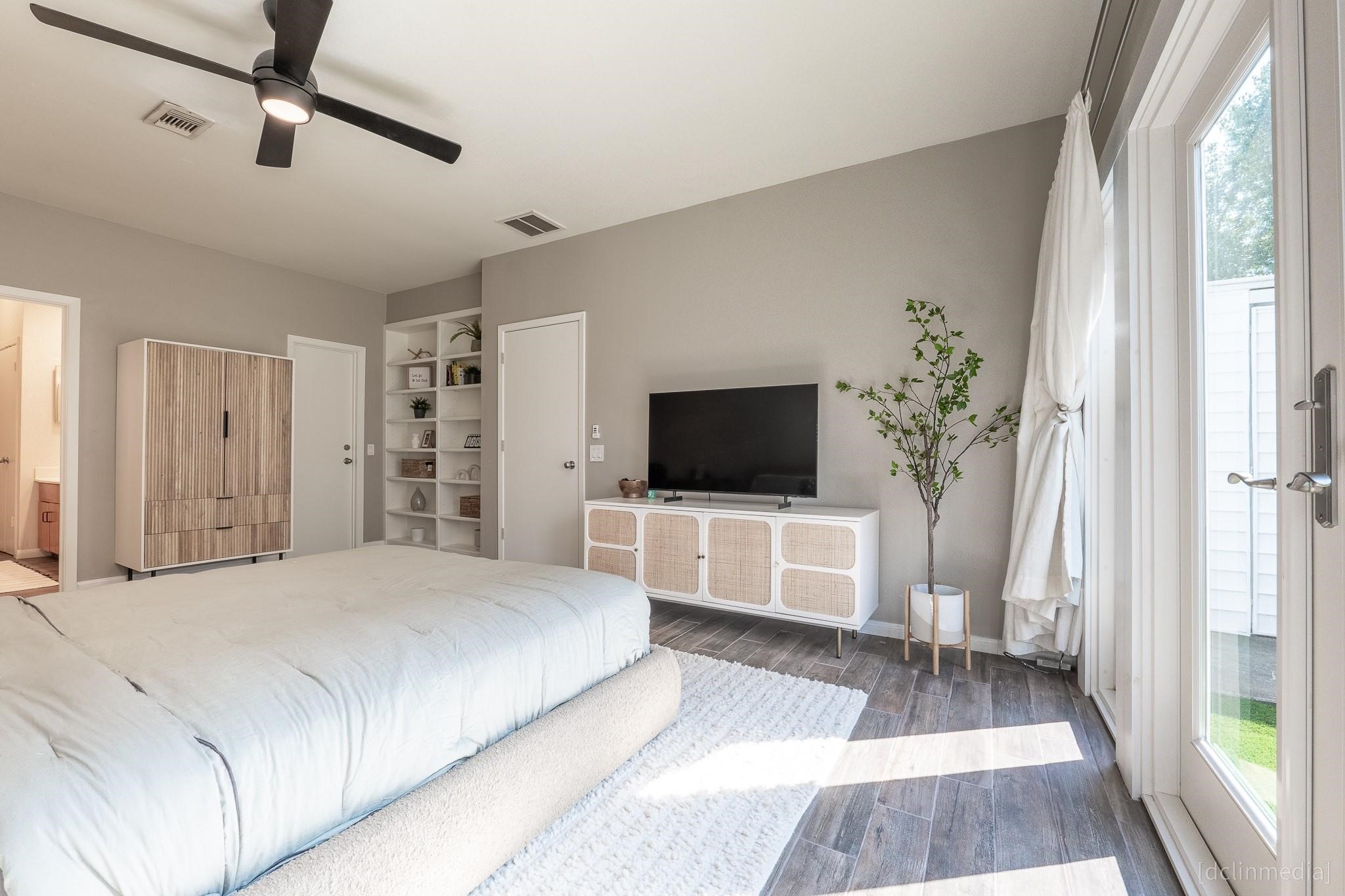 2002 Norfolk Street, Unit A Houston, TX 77098 - Photo 24 of 35 a bedroom with a large bed and a flat screen tv