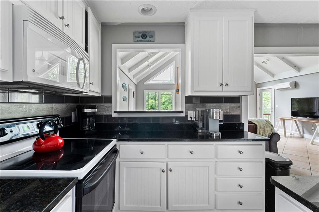 221 Reece Creek Road West Blairsville, GA 30512 - Photo 18 of 42 a kitchen with white cabinets a stove and a window