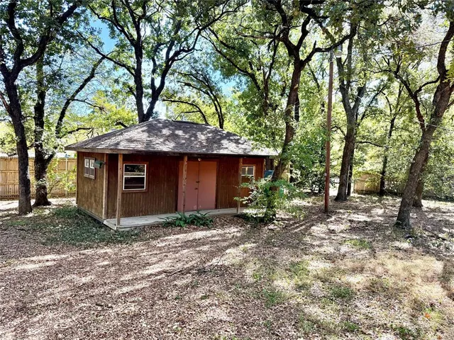 a view of a house with large trees and a barn