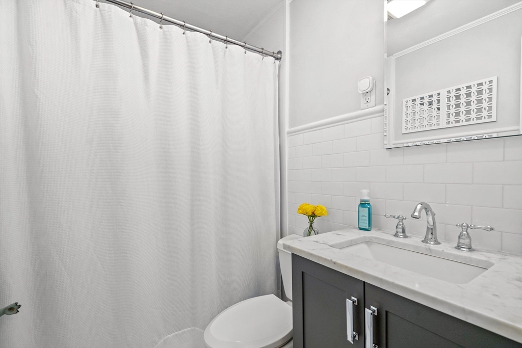 7 Leonard Circle Medford, MA 02155 - Photo 16 of 33 a bathroom with a granite countertop sink and a mirror