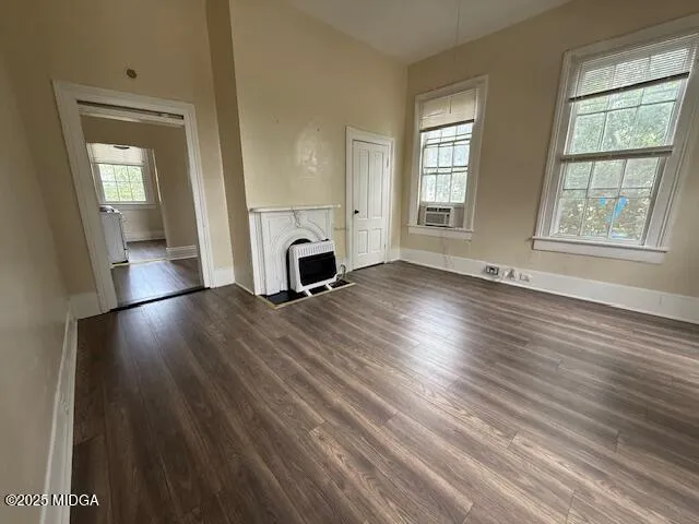a view of empty room with a fireplace and wooden floor