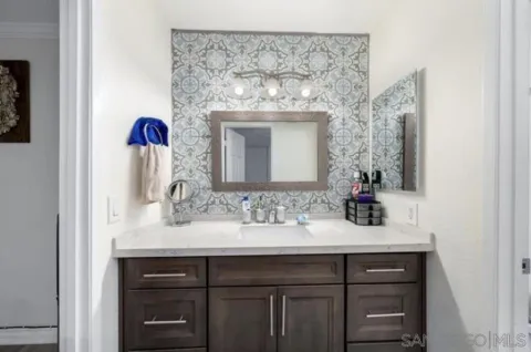 a bathroom with a sink vanity and a mirror