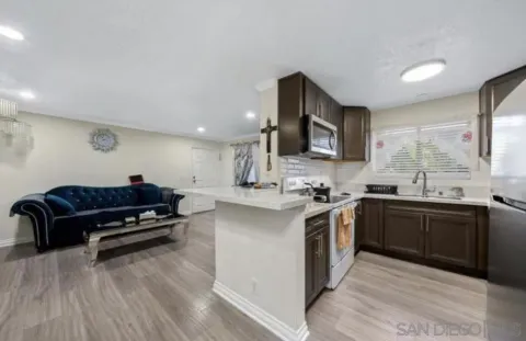 a kitchen with stainless steel appliances granite countertop a sink dishwasher stove top oven and wooden cabinets