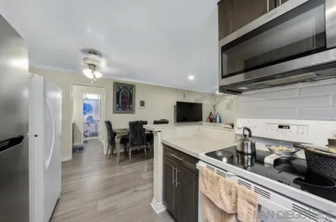 a kitchen with sink a refrigerator and chairs