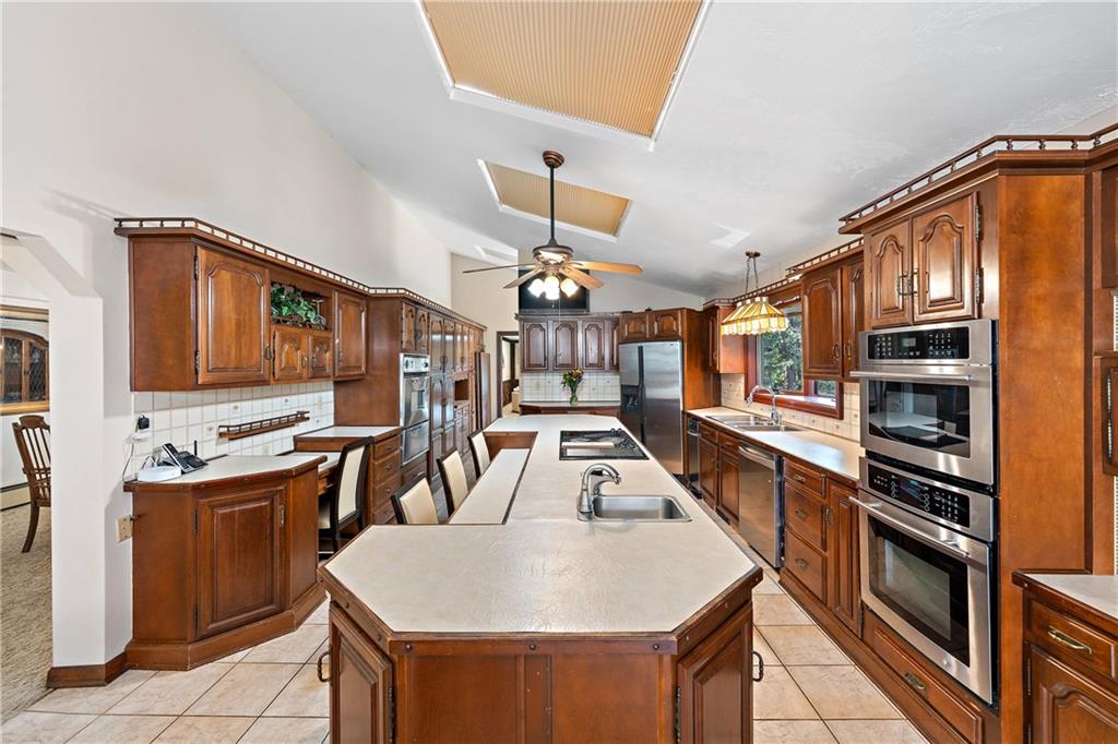 114 Pine Manor Sewickley, PA 15143 - Photo 4 of 40 a kitchen with stainless steel appliances granite countertop a sink a stove and cabinets
