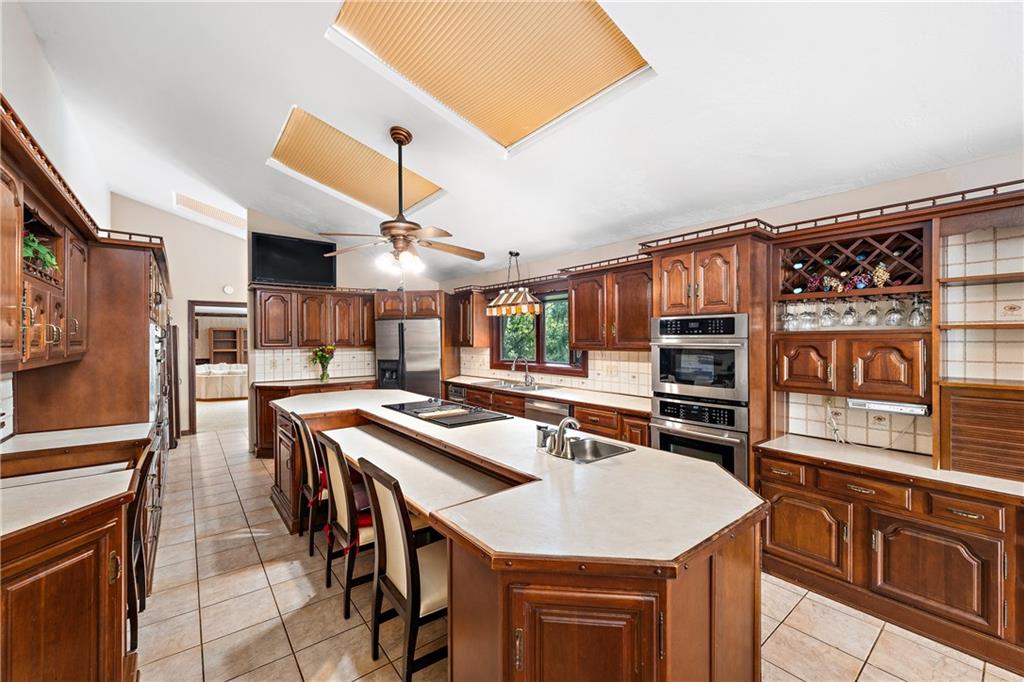 114 Pine Manor Sewickley, PA 15143 - Photo 5 of 40 a kitchen with stainless steel appliances kitchen island granite countertop a stove a sink and a refrigerator