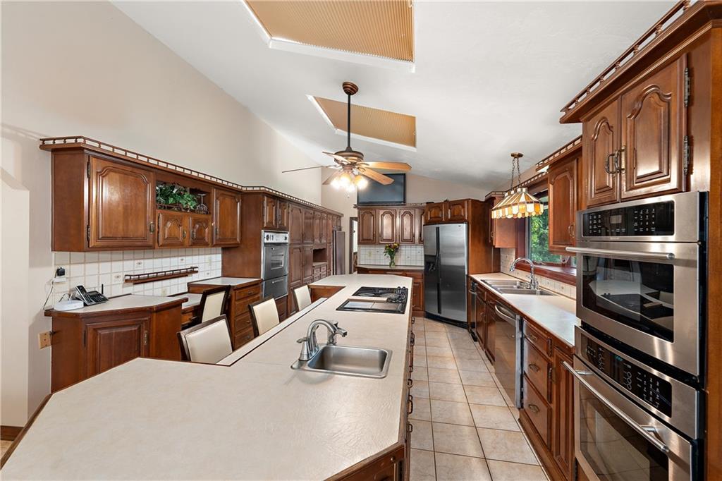 114 Pine Manor Sewickley, PA 15143 - Photo 6 of 40 a kitchen with stainless steel appliances kitchen island granite countertop a sink dishwasher stove and oven