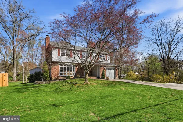 a large tree in front of a brick house