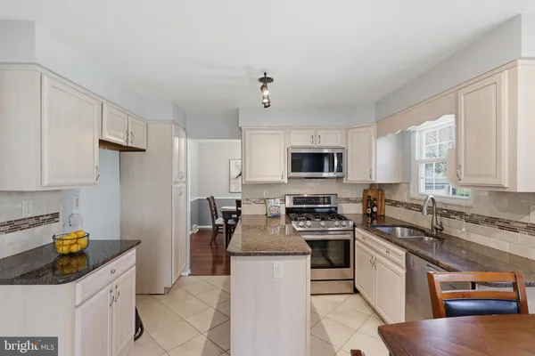a kitchen with stainless steel appliances granite countertop a sink stove and cabinets