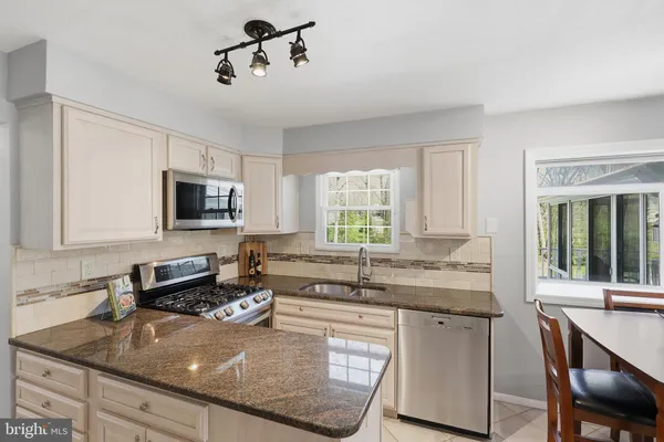 a kitchen with stainless steel appliances granite countertop a stove microwave and refrigerator