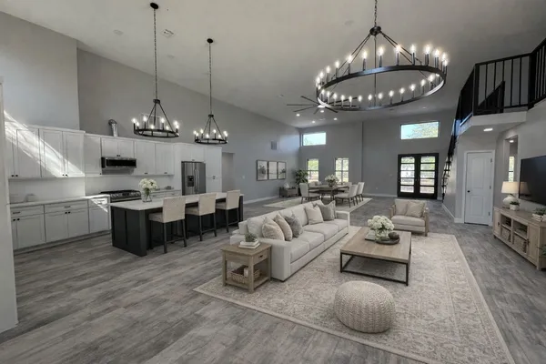a large kitchen with a lot of white cabinets appliances and a chandelier