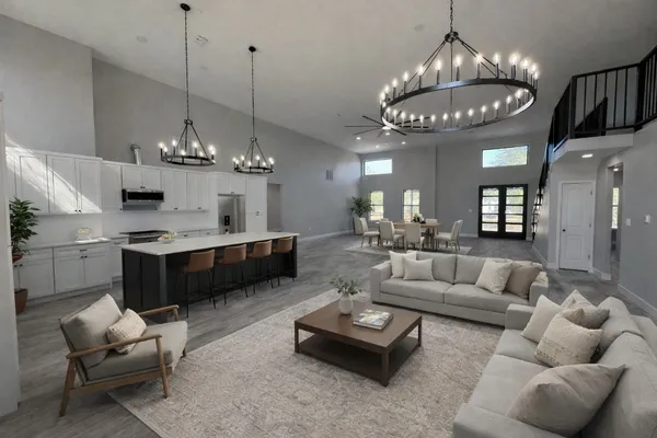 a large kitchen with stainless steel appliances a large center island attached withe living room