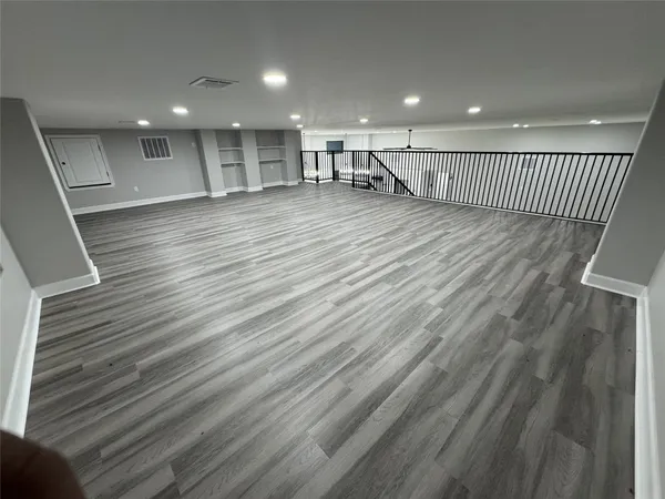 a view of an empty room with wooden floor