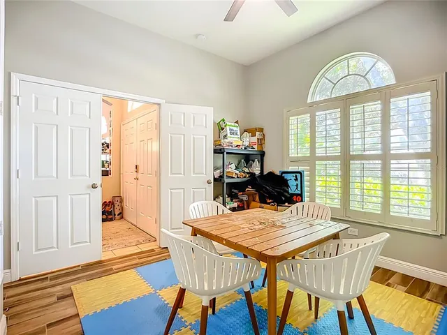 a view of a dining room with furniture a chandelier and wooden floor