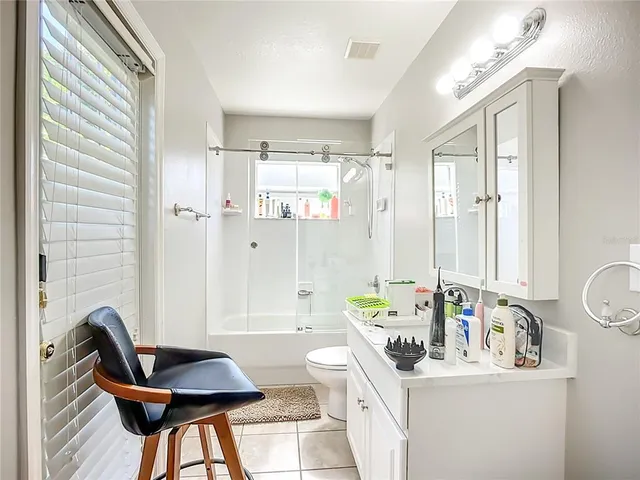 a bathroom with a granite countertop sink a toilet a mirror and shower