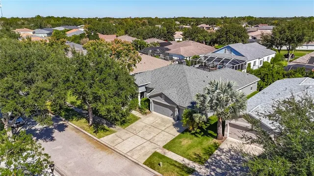 an aerial view of a house with garden space and lake view in back