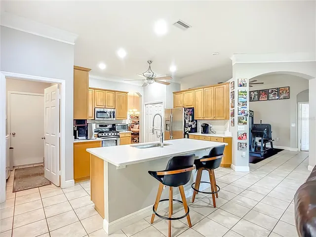 a kitchen with stainless steel appliances kitchen island granite countertop a sink and a refrigerator