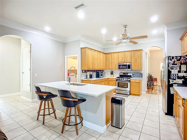 a kitchen with stainless steel appliances a table and chairs in it