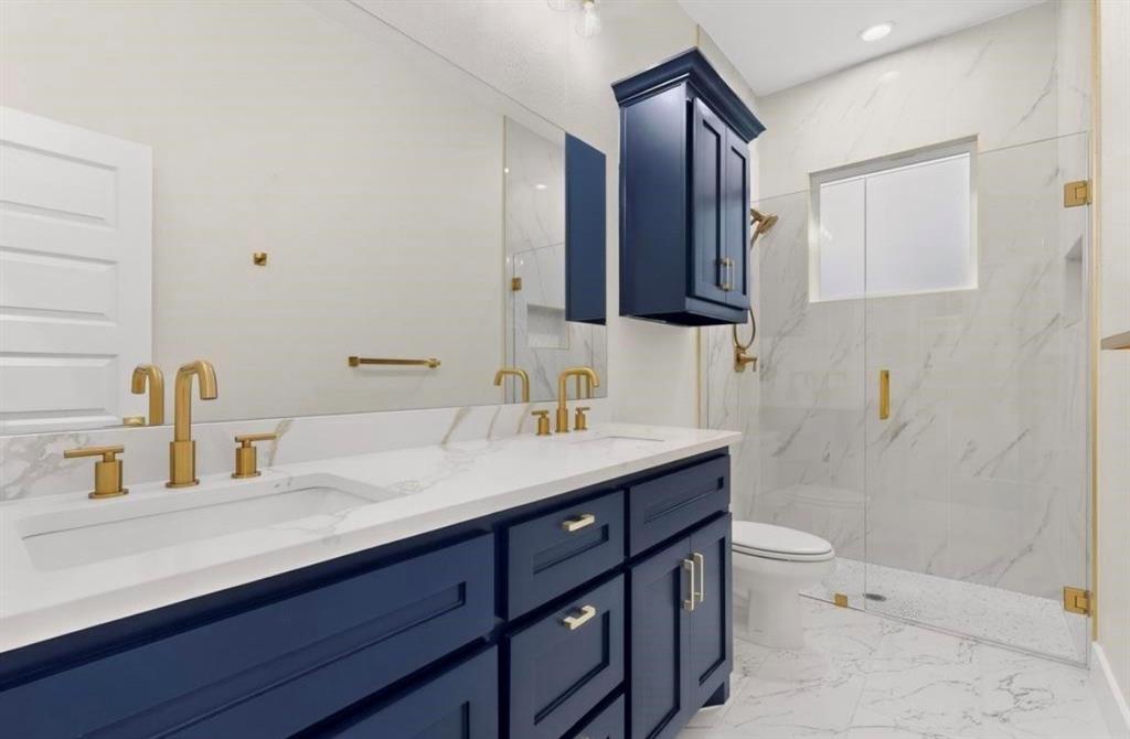 335 Cross Tie Ranch Road Trinidad, TX 75163 - Photo 25 of 30 Double vanity with undermount sinks, white countertop, and gold-finish fixtures