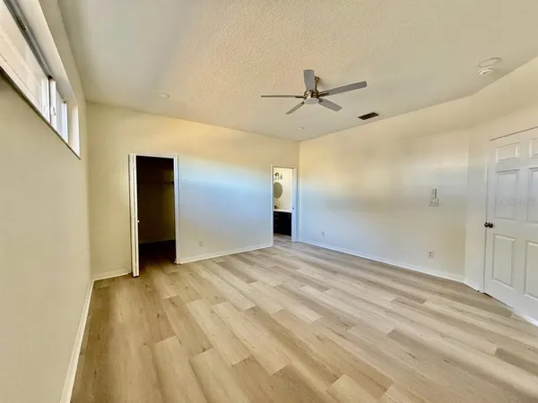 a view of empty room with wooden floor