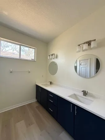a bathroom with double vanity sink and mirror