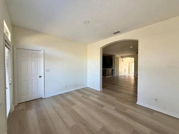 a view of a hallway with wooden floor and closet
