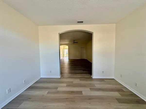 an empty room with wooden floor and mirror