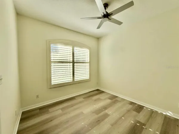 a view of a room with a window and a ceiling fan