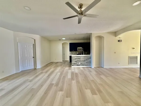 a view of empty room with wooden floor and a ceiling fan
