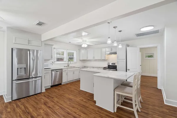 a kitchen with white cabinets and stainless steel appliances
