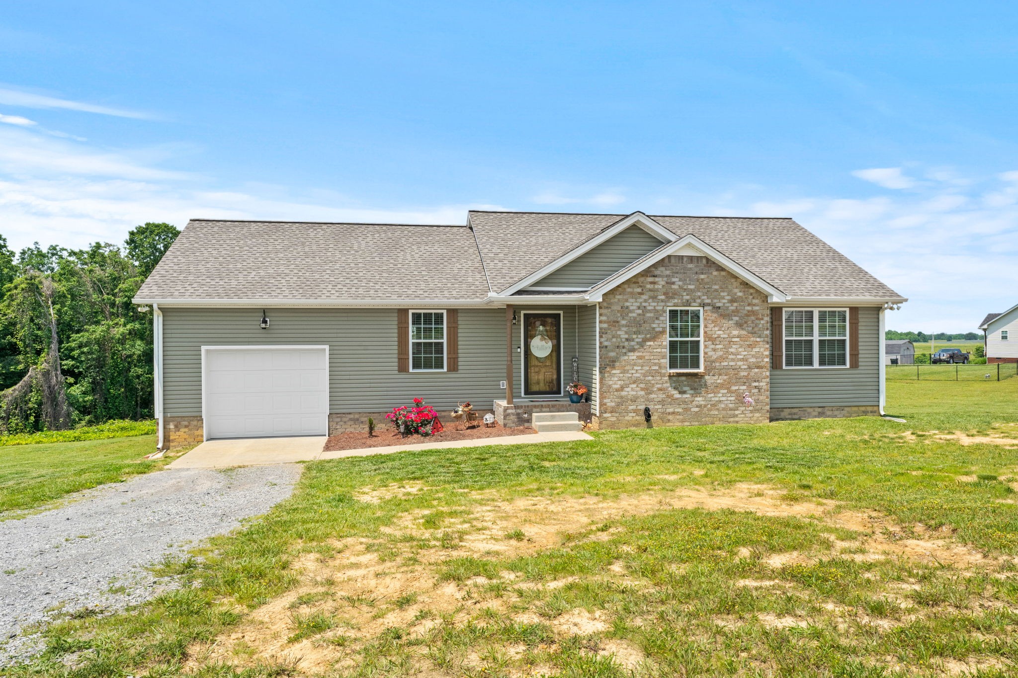 1199 North Corinth Road Portland, TN 37148 - Photo 2 of 22 a front view of a house with a yard and garage