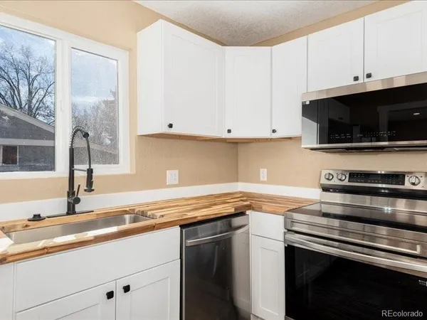 a kitchen with stainless steel appliances granite countertop a sink a stove and a microwave