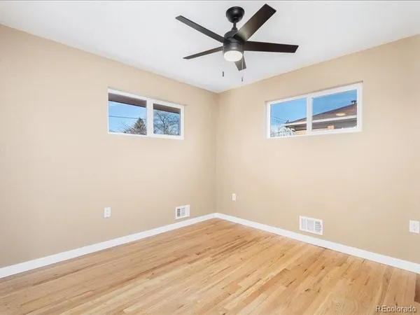an empty room with a window and a ceiling fan