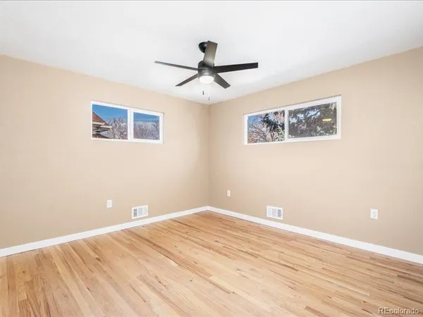 a view of a big room with wooden floor and windows