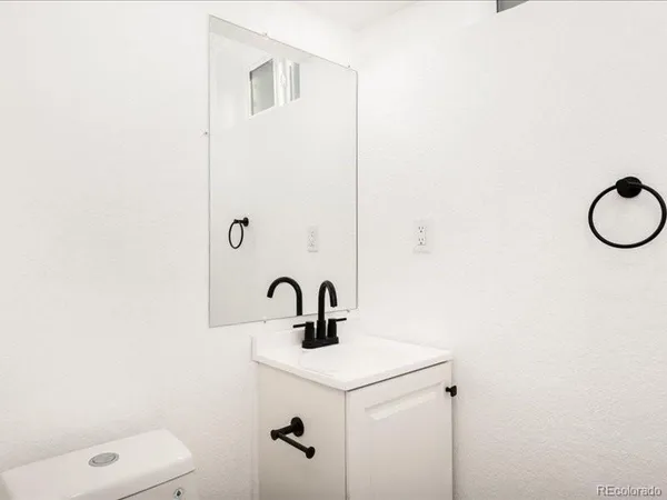 a bathroom with a sink a toilet and mirror