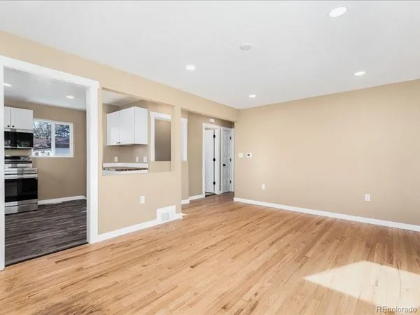 a view of a kitchen with wooden floor and a sink