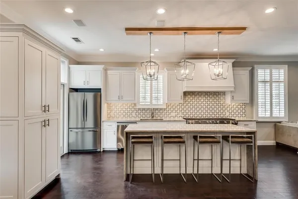 a kitchen with stainless steel appliances granite countertop a kitchen island a stove and a refrigerator