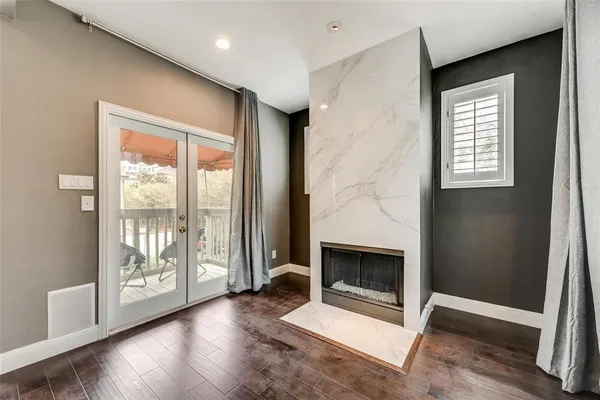 a view of a livingroom with wooden floor and a fireplace
