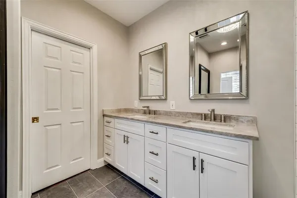 a bathroom with a double vanity sink and mirror