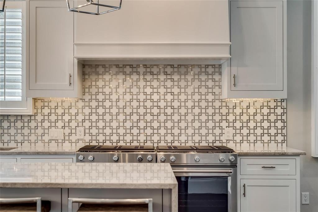 2902 North Pearl Street Dallas, TX 75201 - Photo 4 of 36 Kitchen with white cabinetry, tasteful backsplash, stainless steel gas range oven, and light stone counters